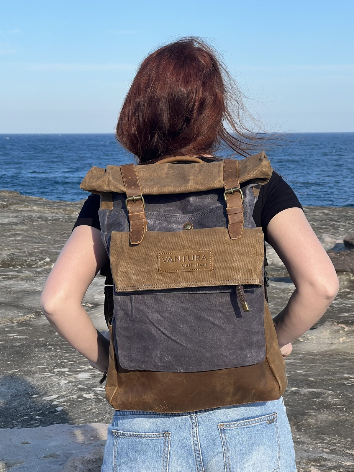 Woman wearing the leather and waxed canvas backpack by the sea