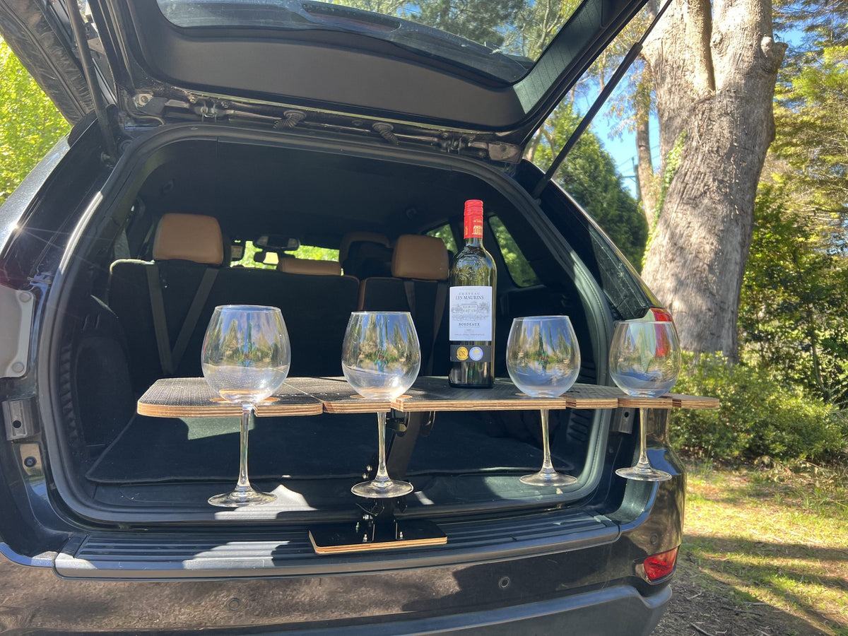 Wine glasses on the wooden Bootlid table at the open boot