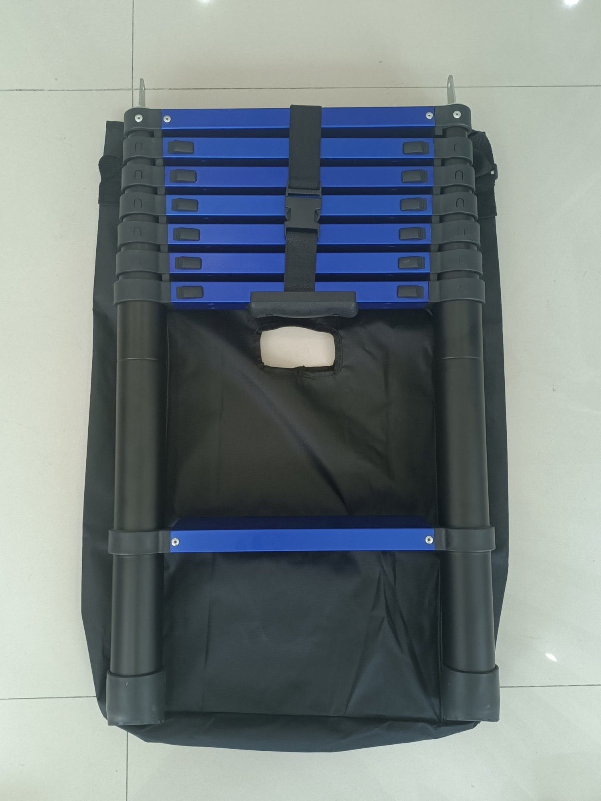 Telescopic ladder partly packed in its carry bag