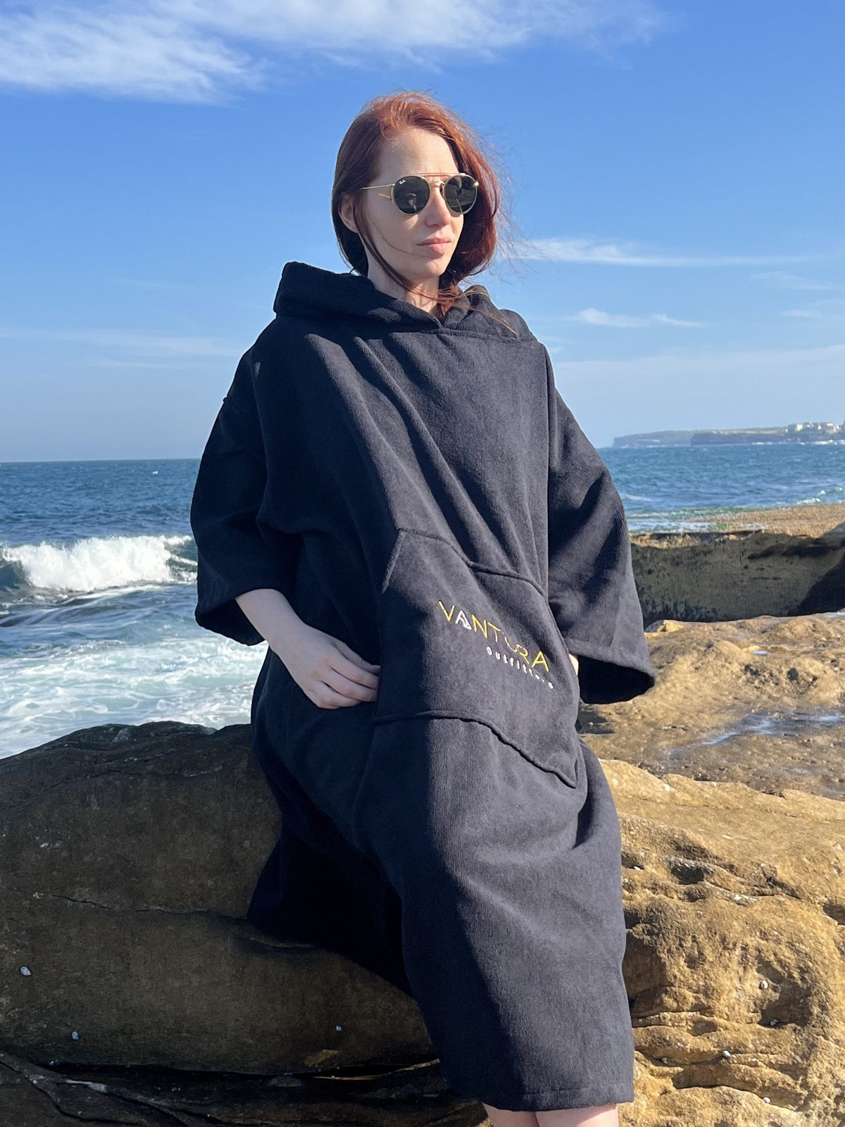 Woman wearing the hooded changing poncho at the beach